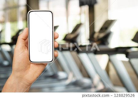 Blurred gym background, sports fitness center with treadmills and exercise equipment in defocus. Abstract sport background. Space for design. Blurred gym background, sports fitness center with treadmills and exercise equipment in defocus. Abstract sport background. Space for design. 128829526