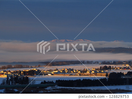初冬的清晨，豬苗代湖霧氣瀰漫，朝陽照射在白雪皚皚的街道上，遠處的雪山巍峨聳立，景色十分壯觀。 128829753