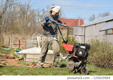Young man engaged in household chores and small-scale rural farming, tending to his garden with care and dedication. His daily routine reflects a sustainable and self-sufficient way of life Young man engaged in household chores and small-scale rural farming, tending to his garden with care and dedication. His daily routine reflects a sustainable and self-sufficient way of life 128829964