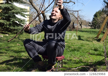 Young man engaged in household chores and small-scale rural farming, tending to his garden with care and dedication. His daily routine reflects a sustainable and self-sufficient way of life 128829968