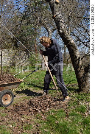Young man engaged in household chores and small-scale rural farming, tending to his garden with care and dedication. His daily routine reflects a sustainable and self-sufficient way of life 128830026