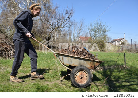 Young man engaged in household chores and small-scale rural farming, tending to his garden with care and dedication. His daily routine reflects a sustainable and self-sufficient way of life Young man engaged in household chores and small-scale rural farming, tending to his garden with care and dedication. His daily routine reflects a sustainable and self-sufficient way of life 128830032