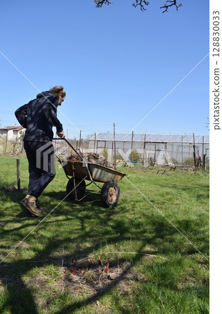 Young man engaged in household chores and small-scale rural farming, tending to his garden with care and dedication. His daily routine reflects a sustainable and self-sufficient way of life Young man engaged in household chores and small-scale rural farming, tending to his garden with care and dedication. His daily routine reflects a sustainable and self-sufficient way of life 128830033