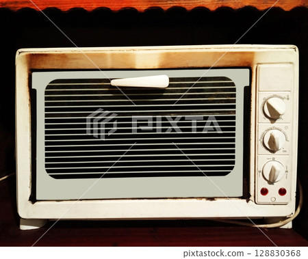 Old electric oven built into a sideboard shelf 128830368