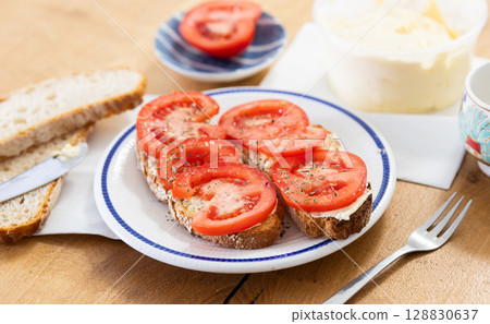two bruschettas with tomato slices on a plate 128830637