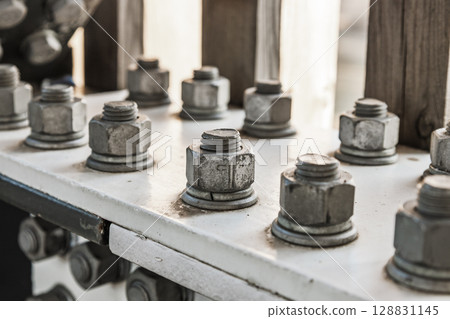 Close up of galvanized nuts and bolts securing steel flange in modern architectural frame 128831145