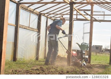 Young man engaged in household chores and small-scale rural farming, tending to his garden with care and dedication. His daily routine reflects a sustainable and self-sufficient way of life Young man engaged in household chores and small-scale rural farming, tending to his garden with care and dedication. His daily routine reflects a sustainable and self-sufficient way of life 128831328