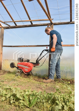 Young man engaged in household chores and small-scale rural farming, tending to his garden with care and dedication. His daily routine reflects a sustainable and self-sufficient way of life 128831340
