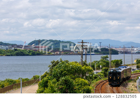 The Kiha 47 series express train "Kawasemi Yamasemi" heading towards Wakamatsu along Dokai Bay. 128832505