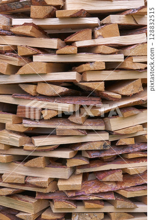 Stacked firewood pile showing natural wooden logs with rough texture and bark Stacked firewood pile showing natural wooden logs with rough texture and bark 128832515