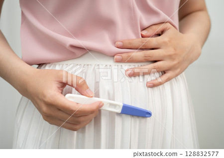Asian holding pregnancy test for female of ovulation day, fetus, maternity, childbirth, birth control. 128832577