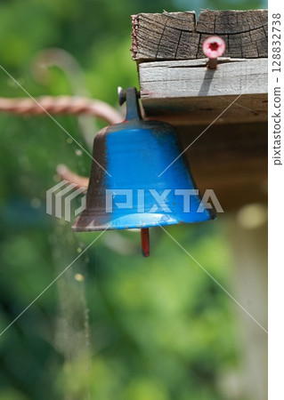 Blue bell hanging from a wooden beam Blue bell hanging from a wooden beam 128832738