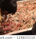Children scooping goldfish at a festival 128833110