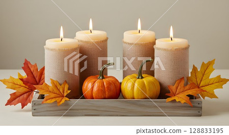 Autumn decoration with candles, pumpkins, and maple leaves on a rustic wooden tray. Fall holiday concept for Thanksgiving. 128833195