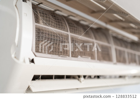 Dirty in dust and mold air conditioner filter close-up. Home air conditioner maintenance 128833512