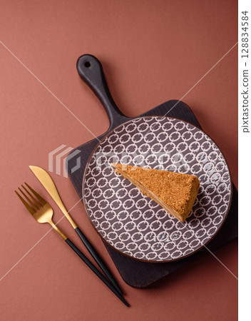 A slice of honey puff cake or pumpkin, carrot and cream pie, vegan sweets 128834584