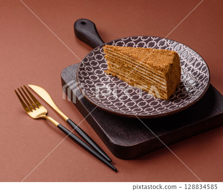 A slice of honey puff cake or pumpkin, carrot and cream pie, vegan sweets 128834585