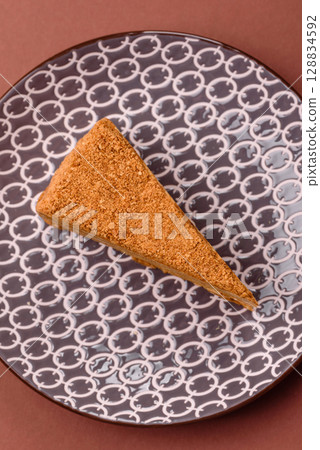 A slice of honey puff cake or pumpkin, carrot and cream pie, vegan sweets 128834592