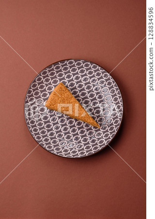 A slice of honey puff cake or pumpkin, carrot and cream pie, vegan sweets 128834596