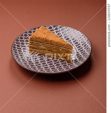 A slice of honey puff cake or pumpkin, carrot and cream pie, vegan sweets 128834597