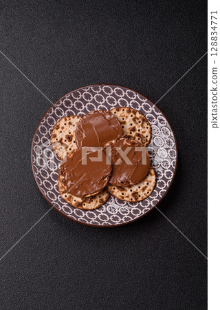Matzah with chocolate paste for the Jewish holiday of passover Matzah with chocolate paste for the Jewish holiday of passover 128834771