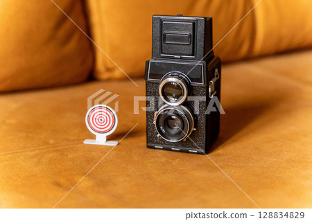 Vintage twin lens reflex camera focusing on target goal achievement concept Vintage twin lens reflex camera focusing on target goal achievement concept 128834829
