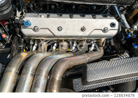 Powerful engine showing exhaust manifold and carbon fiber part 128834876