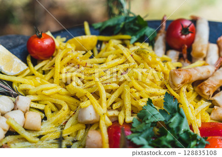 French fries with seafood and vegetables creating delicious culinary dish French fries with seafood and vegetables creating delicious culinary dish 128835108