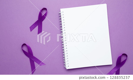 Mock up notebook. Purple Epilepsy Awareness Day, purple ribbon held, symbol of support Mock up notebook. Purple Epilepsy Awareness Day, purple ribbon held, symbol of support 128835237