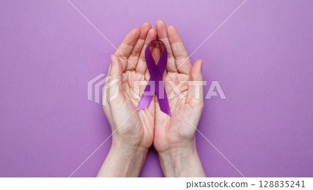 Purple ribbon held, symbol of support. Purple Epilepsy Awareness Day Purple ribbon held, symbol of support. Purple Epilepsy Awareness Day 128835241