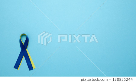 Symbolizing World Down Syndrome Day. A yellow and blue awareness ribbon Symbolizing World Down Syndrome Day. A yellow and blue awareness ribbon 128835244
