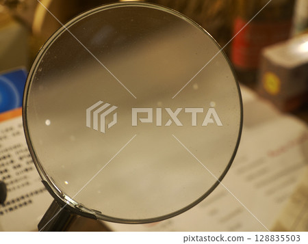 old magnifying glass detail close up 128835503