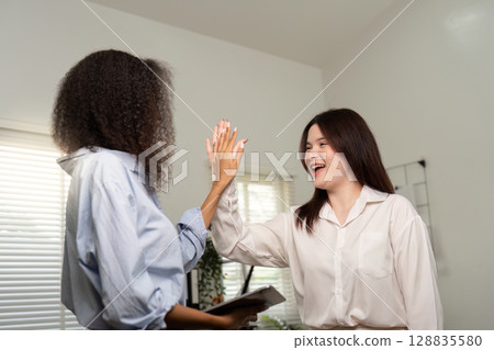 Joyful High-Five Between Colleagues in Bright Office Joyful High-Five Between Colleagues in Bright Office 128835580