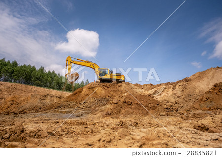 A caterpillar tractor works with a bucket in a sand pit. Sand mining A caterpillar tractor works with a bucket in a sand pit. Sand mining 128835821