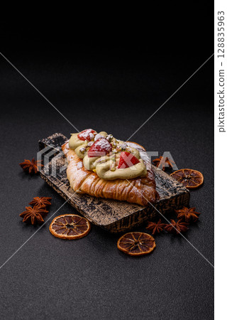 Food for breakfast sweet strawberry croissants with chocolate filling 128835963