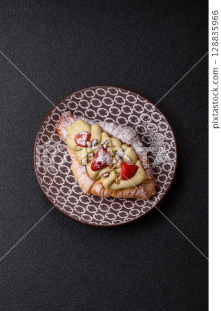 Food for breakfast sweet strawberry croissants with chocolate filling 128835966