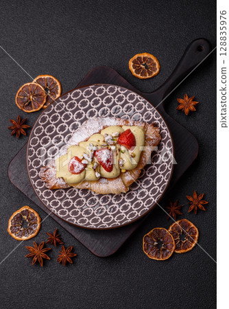 Food for breakfast sweet strawberry croissants with chocolate filling 128835976