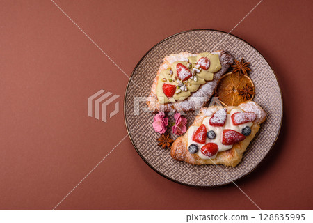 Food for breakfast sweet strawberry croissants with chocolate filling 128835995