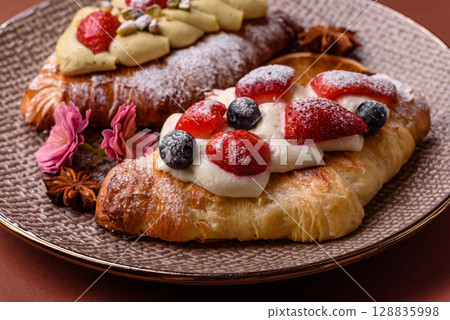 Food for breakfast sweet strawberry croissants with chocolate filling 128835998