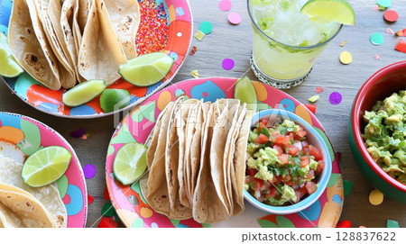 Cinco de Mayo tacos presented with traditional Mexican garnishes, background 128837622
