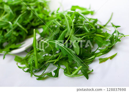 Bunch of green fresh arugula leaves on table 128837698