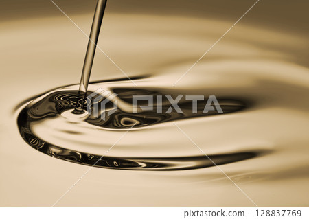 The oil flows and collects into a drop. The texture of the cosmetic product. The oil flows and collects into a drop. The texture of the cosmetic product. 128837769