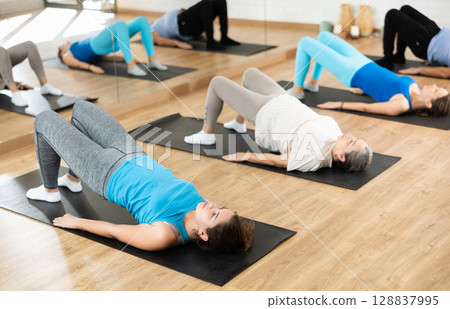 Young girl performing glute bridge during training 128837995