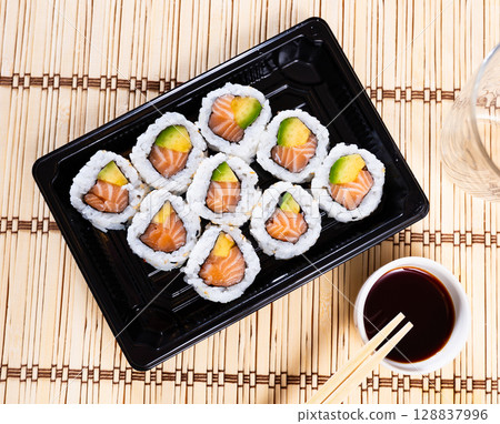 Tasty sushi california roll with salmon and avocado Tasty sushi california roll with salmon and avocado 128837996