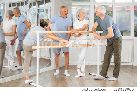 Elderly ballet lovers communicate with each other during break between classes in choreographic studio 128838069