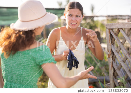 Adult and young woman quarreling in garden 128838070