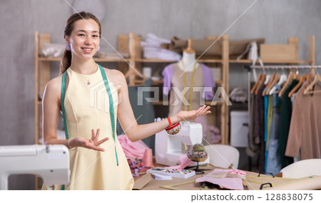 Seamstress girl invites you to visit sewing studio Seamstress girl invites you to visit sewing studio 128838075