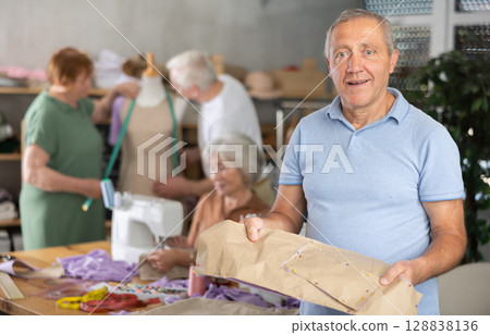 Elderly man with pattern at sewing master class 128838136
