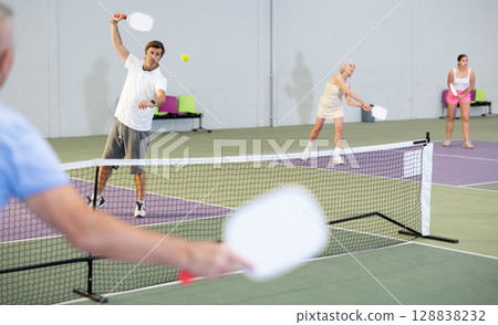 Man and woman training to play pickleball tennis on the pickleball cour Man and woman training to play pickleball tennis on the pickleball cour 128838232