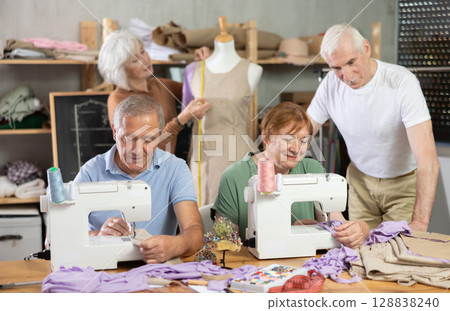 Senior woman work with mannequin at sewing school studio, others people sew and talking Senior woman work with mannequin at sewing school studio, others people sew and talking 128838240